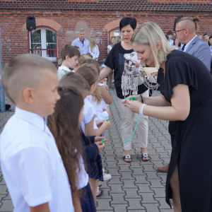 Uroczyste rozpoczęcie roku szkolnego 2025/26 na boisku szkolnym. Wręczanie upominków uczniom klas pierwszych.