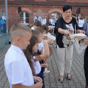 Uroczyste rozpoczęcie roku szkolnego 2025/26 na boisku szkolnym. Wręczanie upominków uczniom klas pierwszych